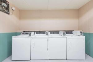 a laundry room with two washes and three machines at Super 8 by Wyndham Black Mountain in Black Mountain