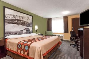 a hotel room with a bed and a flat screen tv at Super 8 by Wyndham LaGrande in La Grande