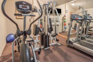 un gimnasio con varias cintas de correr y máquinas cardiovasculares en Days Inn by Wyndham Camp Springs Andrews AFB en Camp Springs