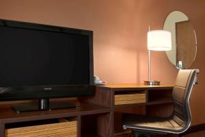 a flat screen tv sitting on a desk with a chair at Super 8 by Wyndham East Peoria in Peoria