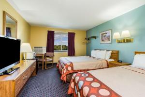 a hotel room with two beds and a flat screen tv at Super 8 by Wyndham Fergus Falls in Fergus Falls