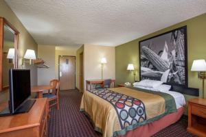 a hotel room with a bed and a flat screen tv at Super 8 by Wyndham Mendota in Mendota