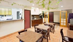 
a kitchen with a table, chairs and a refrigerator at Super 8 by Wyndham Yucca Val/Joshua Tree Nat Pk Area in Yucca Valley
