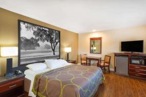 a hotel room with a bed and a flat screen tv at Super 8 by Wyndham Martinez in Martinez