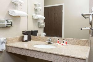 een badkamerbar met een wastafel en een spiegel bij Super 8 by Wyndham Sterling CO in Sterling