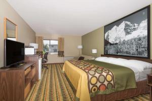 a hotel room with a bed and a flat screen tv at Super 8 by Wyndham Sterling CO in Sterling
