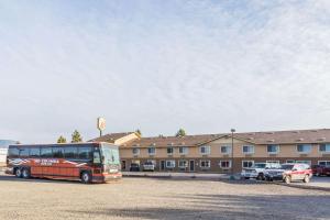 a bus parked in a parking lot in front of a building at Super 8 by Wyndham LaGrande in La Grande
