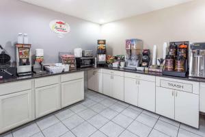 a kitchen with white cabinets and a counter top at Super 8 by Wyndham Mundelein/Libertyville Area in Mundelein