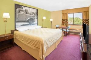 A bed or beds in a room at Super 8 by Wyndham Normal Bloomington