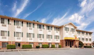 a large white building on a street at Super 8 by Wyndham Fayetteville in Fayetteville