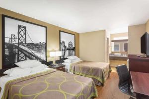 マルティネスにあるSuper 8 by Wyndham Martinezのベッド2台とテレビが備わるホテルルームです。