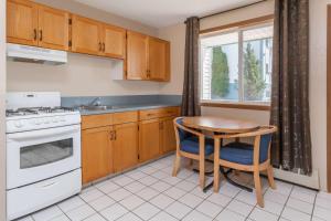 a kitchen with a table and a stove and a sink at Super 8 by Wyndham Medicine Hat AB in Medicine Hat