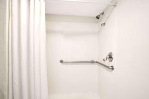 uma casa de banho com uma cortina de chuveiro e uma barra de cortina em Super 8 by Wyndham Orlando International Drive em Orlando