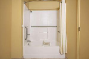 a bathroom with a white tub and a shower at Super 8 by Wyndham Big Cabin/Vinita Area in Vinita +37 photos