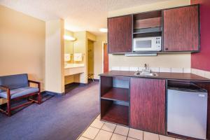 a room with a kitchen with a sink and a microwave at Super 8 by Wyndham Big Cabin/Vinita Area in Vinita