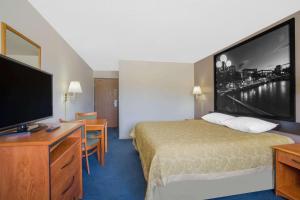a hotel room with a bed and a flat screen tv at Super 8 by Wyndham Winnemucca NV in Winnemucca
