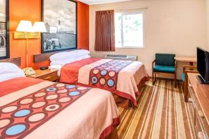 a hotel room with two beds and a television at Super 8 by Wyndham Blair in Blair