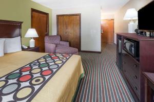 a hotel room with a bed and a television at Super 8 by Wyndham Harrison AR in Harrison