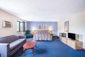 pokój hotelowy z łóżkiem i kanapą w obiekcie Super 8 by Wyndham Hot Springs w mieście Hot Springs