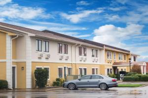 een auto geparkeerd op een parkeerplaats voor een gebouw bij Super 8 by Wyndham Jonesboro in Jonesboro