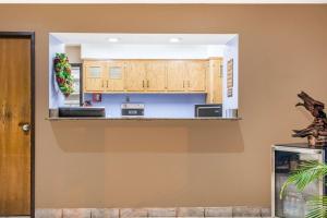 a kitchen with wooden cabinets and a counter top at Super 8 by Wyndham Hot Springs in Hot Springs