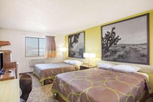 
a hotel room with two beds and a painting on the wall at Super 8 by Wyndham Kingman in Kingman
