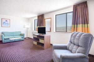 a living room with a chair and a television at Super 8 by Wyndham Kingman in Kingman