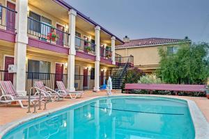 a pool in front of a hotel with chairs and a building at Super 8 by Wyndham Santa Cruz/Beach Boardwalk East in Santa Cruz
