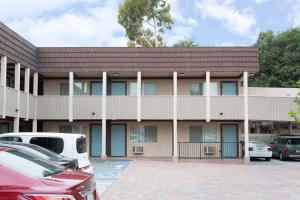 un edificio con coches estacionados en un estacionamiento en Costa Mesa Inn - Newport Beach Area en Costa Mesa