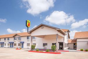 a hotel exterior with a krispy kreme sign at Super 8 by Wyndham Van Buren/Ft. Smith Area in Van Buren