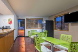 un comedor con mesas verdes y sillas en Super 8 by Wyndham Delmont, en Delmont