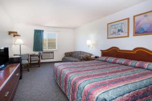 a hotel room with a bed and a television at Super 8 by Wyndham Limon in Limon