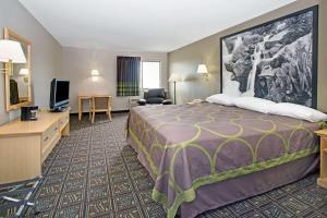 a hotel room with a bed and a flat screen tv at Super 8 by Wyndham Fort Collins in Fort Collins