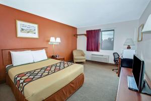 um quarto de hotel com uma cama e uma televisão em Super 8 by Wyndham Crystal Lake em Crystal Lake