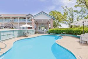 a swimming pool in front of a house at Super 8 by Wyndham Auburn in Auburn