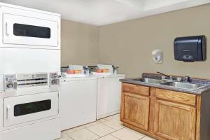 cocina con electrodomésticos blancos y fregadero en Super 8 by Wyndham West Memphis en West Memphis