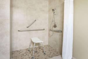 a shower with a stool in a bathroom at Super 8 by Wyndham Montrose in Montrose