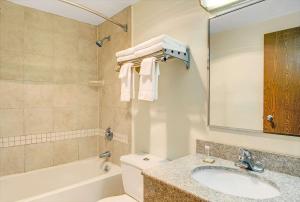 a bathroom with a sink and a tub and a toilet at Super 8 by Wyndham Stamford/New York City Area in Stamford