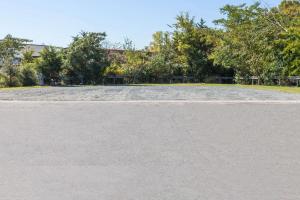 an empty parking lot with trees in the background at Super 8 by Wyndham Charlotte/Amusement Park Area in Charlotte