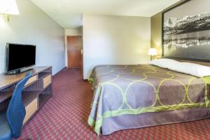 a hotel room with a bed and a flat screen tv at Super 8 by Wyndham Longmont/Del Camino in Longmont