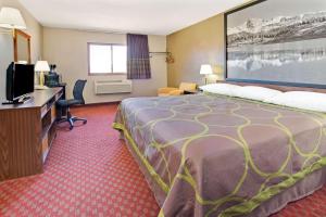 a hotel room with a bed and a flat screen tv at Super 8 by Wyndham Longmont/Del Camino in Longmont
