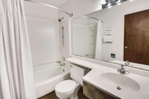 y baño con lavabo, aseo y espejo. en Super 8 by Wyndham Crystal Lake en Crystal Lake