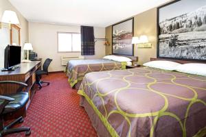 a hotel room with two beds and a flat screen tv at Super 8 by Wyndham Longmont/Del Camino in Longmont