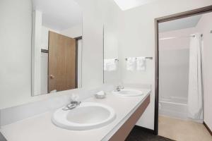 a white bathroom with two sinks and a mirror at FairBridge Inn & Suites Moscow - Pullman in Moscow