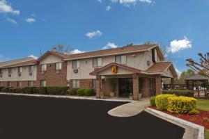 un gran edificio de apartamentos con una carretera delante de él en Super 8 by Wyndham Greenville en Greenville