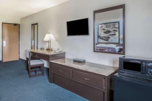 a hotel room with a desk and a bed at Super 8 by Wyndham New Castle in New Castle