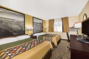 a hotel room with two beds and a desk at Super 8 by Wyndham Nampa in Nampa