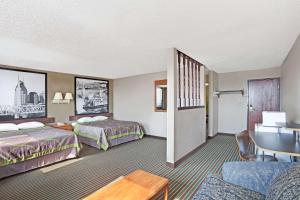 a hotel room with two beds and a table at Super 8 by Wyndham Nashville/ Dntn/ Opryland Area in Nashville