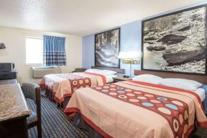 a hotel room with two beds and a television at Super 8 by Wyndham New Castle in New Castle