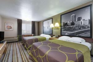 a hotel room with two beds and a large screen at Super 8 by Wyndham Bernalillo in Bernalillo